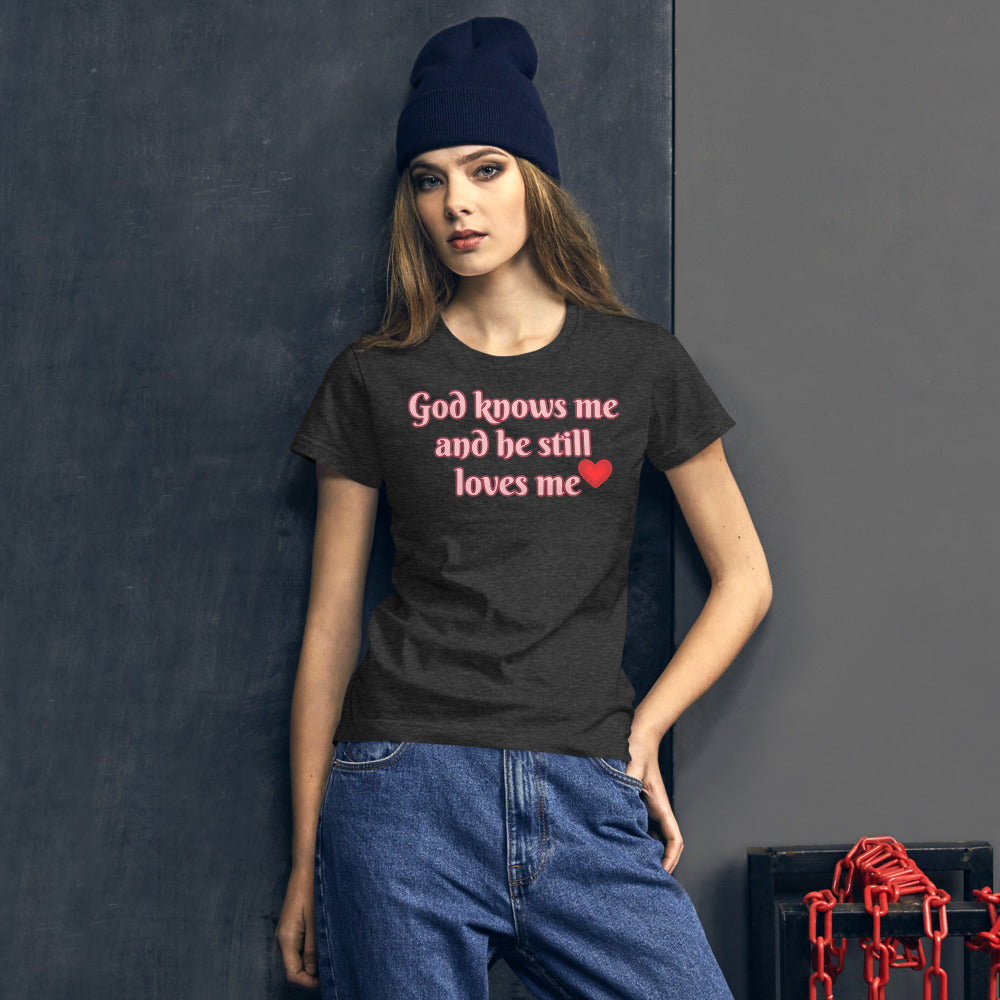 Women's Dark Grey t-shirt with God knows me and he still loves me in Light Pink letters outlined in Burgundy with a red heart